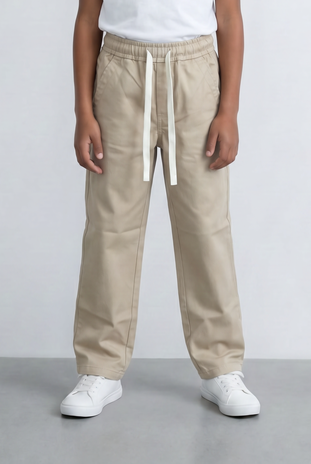 Boy's beige drawstring pants with an elastic waist and casual fit from tomato store.
