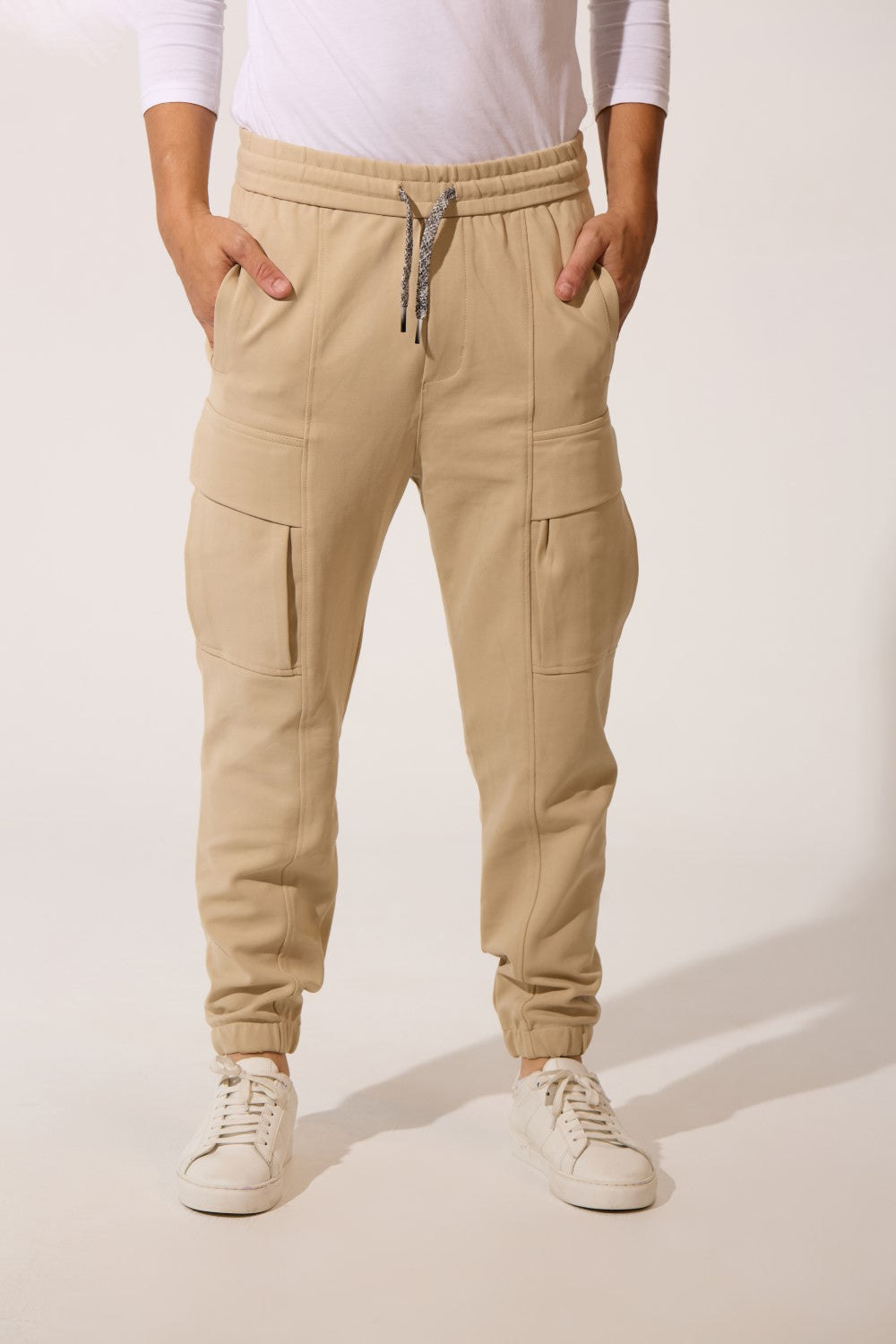 Men’s beige utility cargo fleece sweatpants with flap pockets and drawstring by tomato store.