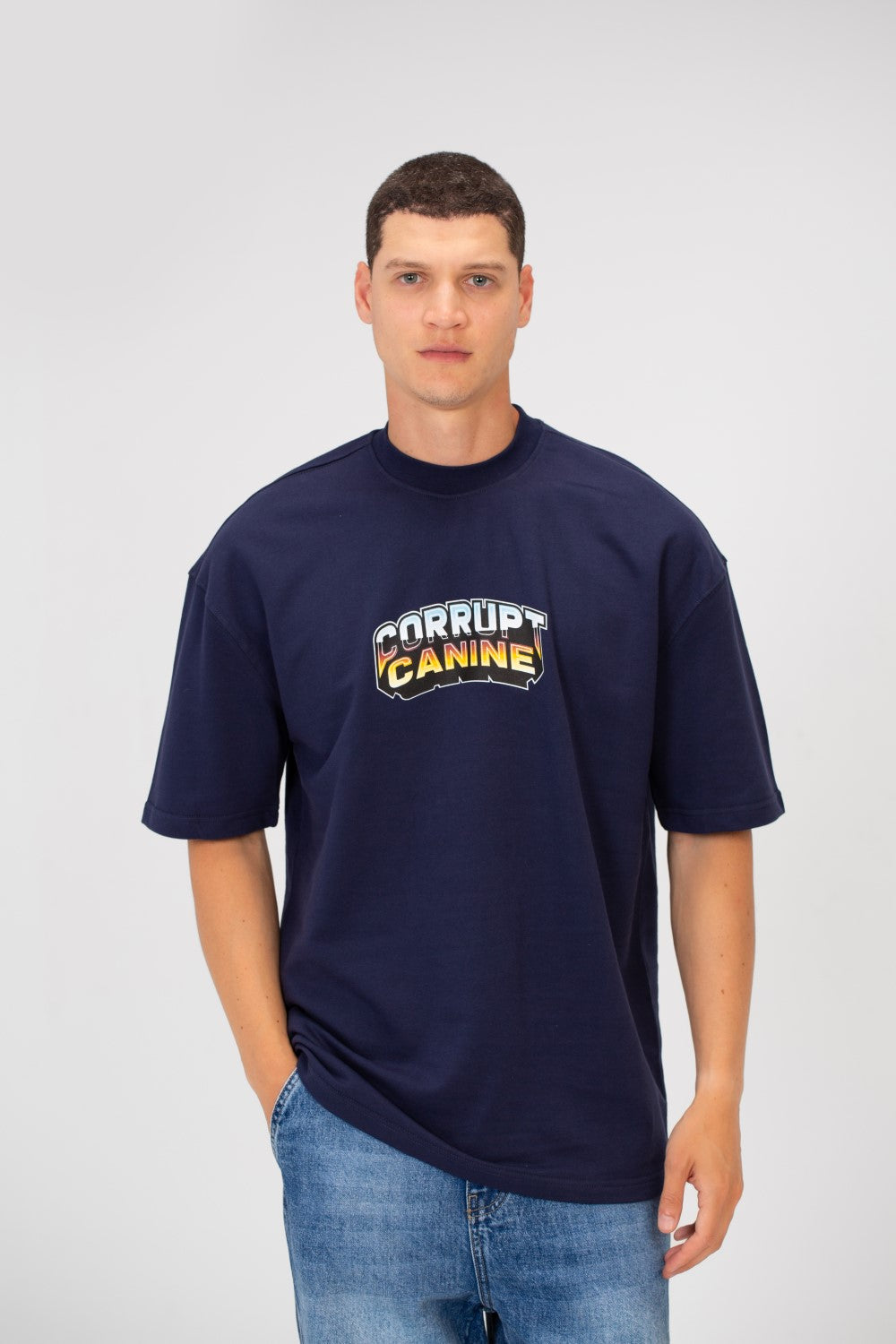 Men’s Oversized Navy T-Shirt with Corrupt Canine chest print by tomato store, paired with blue jeans.