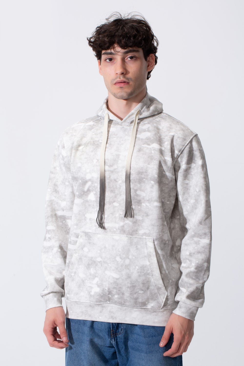 Man wearing a slim-fit, garment-dyed grey camouflage hoodie with white accents and a front pocket.