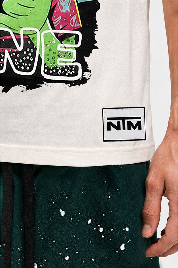 Close-up of a cream t-shirt with a black and white graphic and a "NIM" logo patch.
